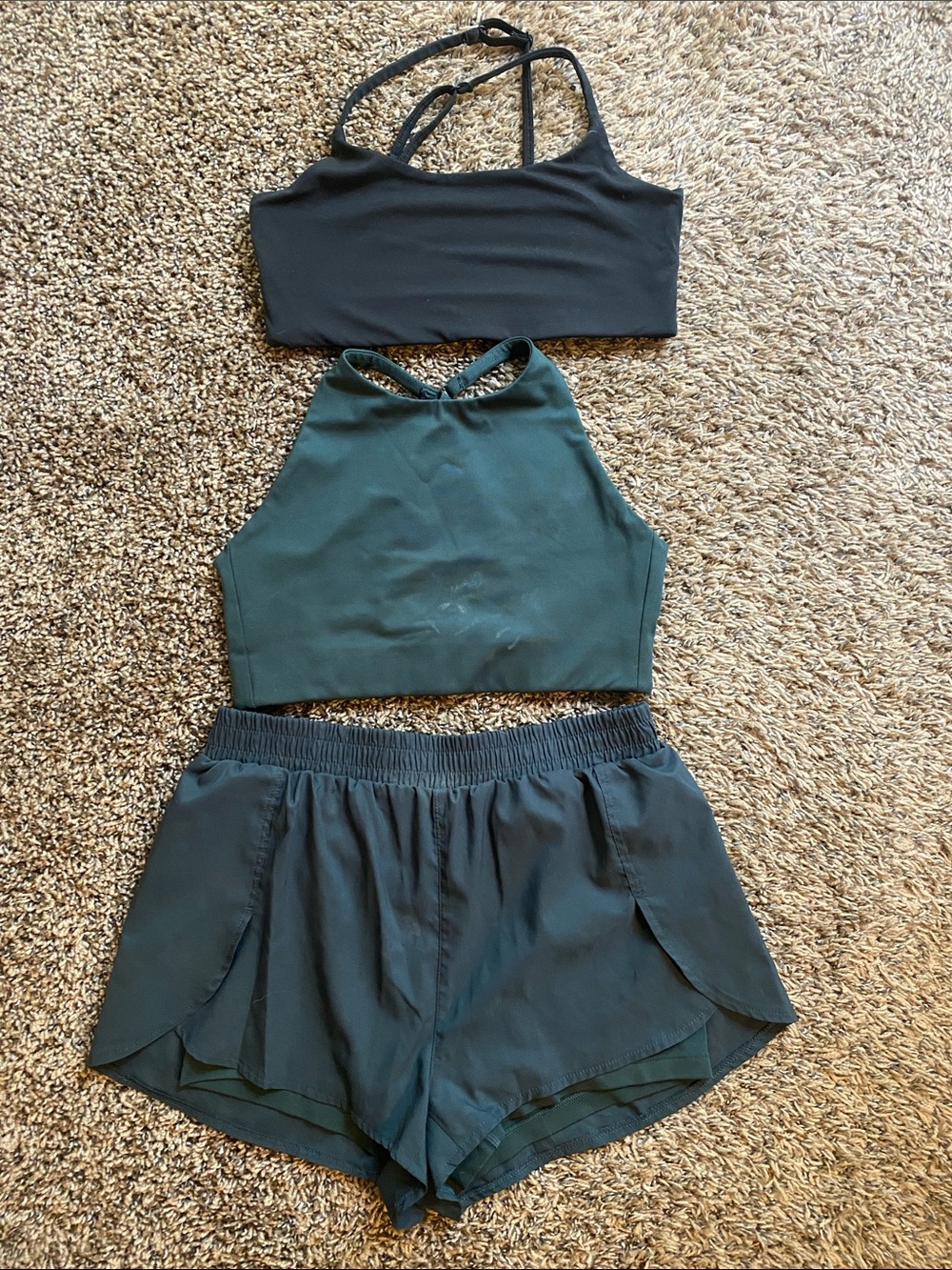 girlfriend collective Black and Dark Green sports bras and green matching shorts